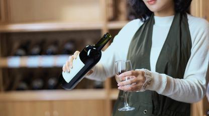 Asian lady selecting a bottle of wine from her cellar