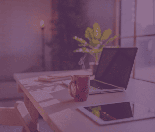 Laptop open on a desk with a cup of coffee