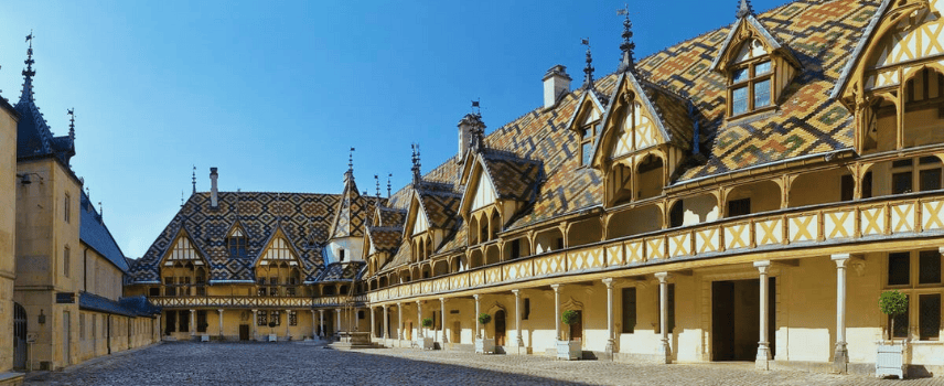 Exterior of the Hotel Dieu in Beaune with the sun falling on the roof's tiles