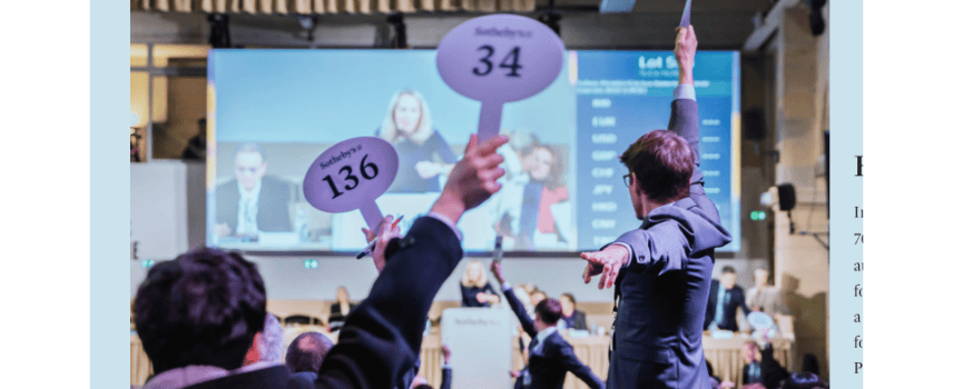 Bidders holding paddles up at auction